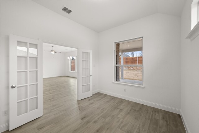 kitchen featuring appliances with stainless steel finishes, sink, light wood-type flooring, decorative light fixtures, and white cabinets