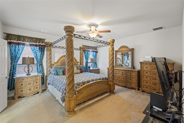 bedroom with visible vents, light colored carpet, and a ceiling fan