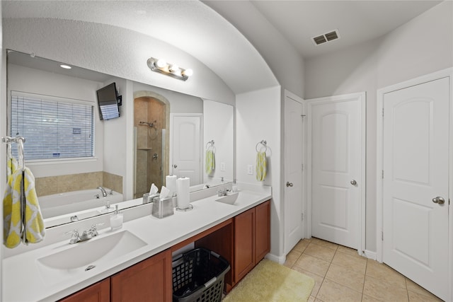 bathroom with visible vents, double vanity, a sink, a shower stall, and a garden tub