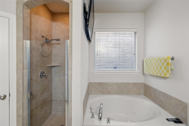 full bathroom featuring a tub with jets and a stall shower