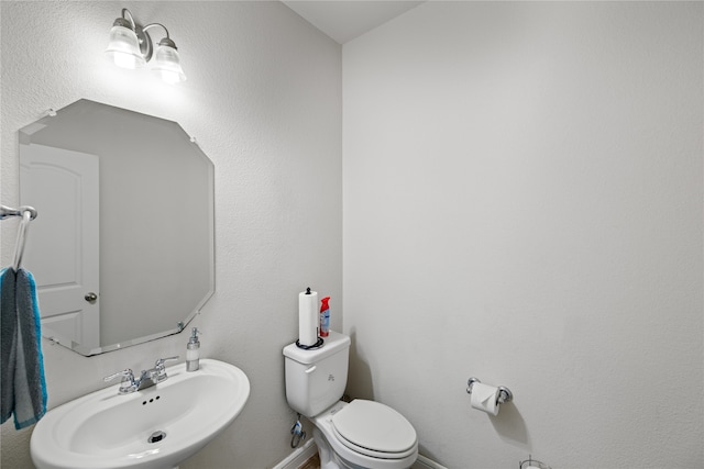 half bathroom with toilet and a sink