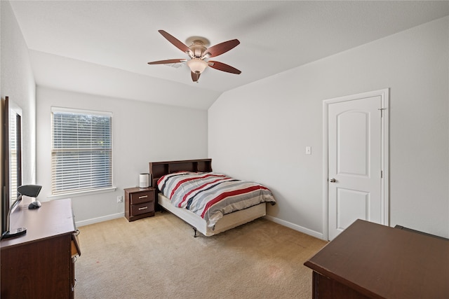 bedroom with vaulted ceiling, light colored carpet, baseboards, and ceiling fan