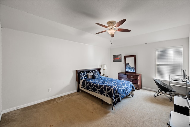 carpeted bedroom with a ceiling fan, a raised ceiling, and baseboards