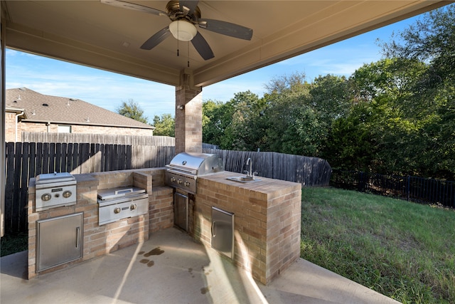 view of patio / terrace with exterior kitchen, area for grilling, a fenced backyard, and a sink