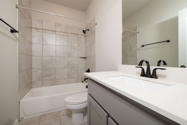 full bathroom featuring tiled shower / bath, vanity, tile patterned flooring, and toilet