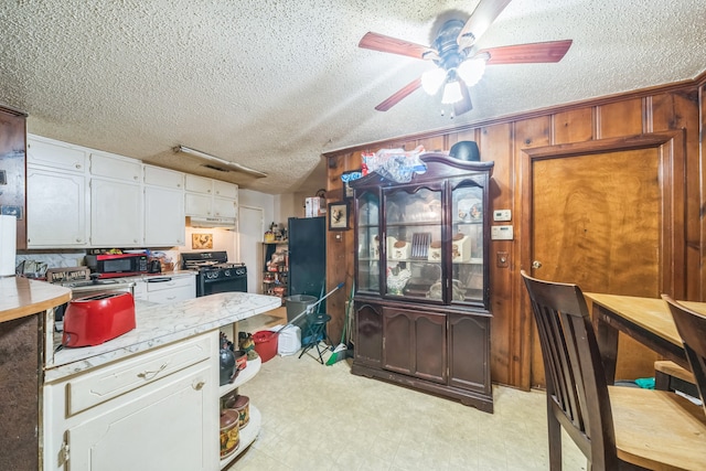 kitchen with a textured ceiling, black appliances, white cabinetry, and ceiling fan