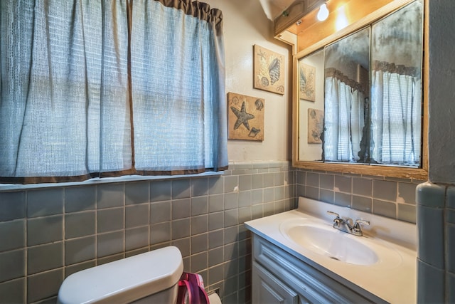 bathroom with tile walls, vanity, and toilet