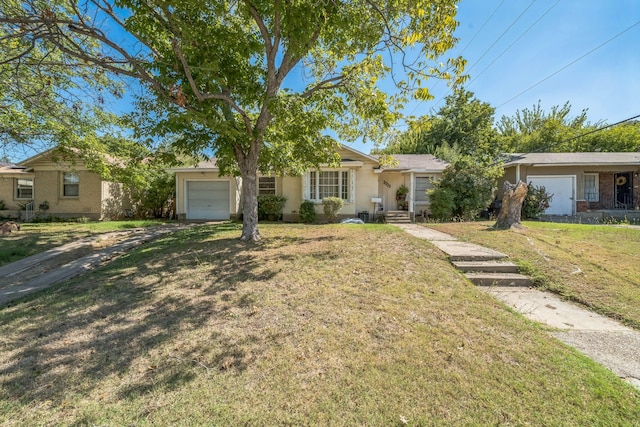 single story home with an attached garage, a front lawn, and stucco siding