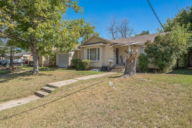 view of front of house with an attached garage, a front yard, and stucco siding