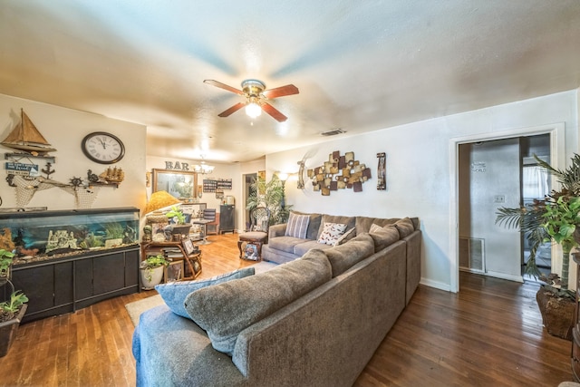 living room featuring ceiling fan with notable chandelier and dark hardwood / wood-style floors