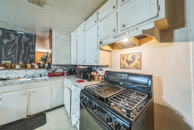 kitchen featuring a textured ceiling, white cabinetry, black range with gas cooktop, and sink