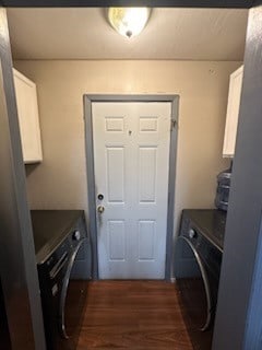 clothes washing area with cabinets, washer and clothes dryer, and dark hardwood / wood-style flooring