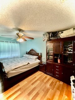 bedroom with ceiling fan, a textured ceiling, and hardwood / wood-style flooring