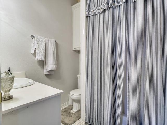 bathroom featuring a shower with shower curtain, vanity, and toilet