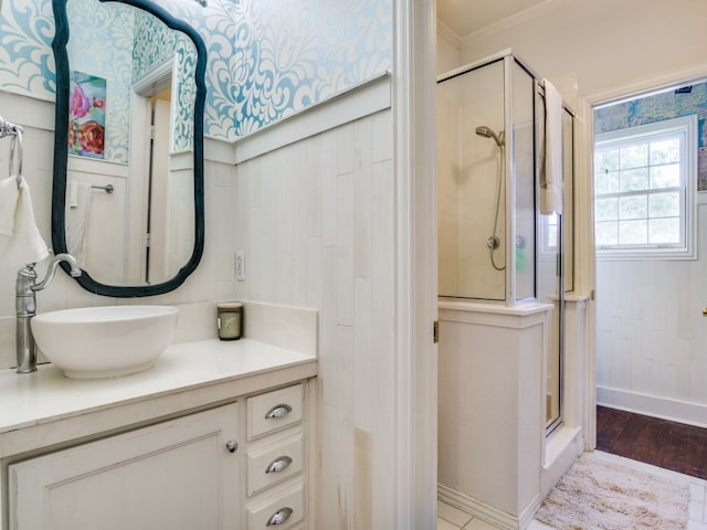 bathroom featuring vanity, hardwood / wood-style flooring, an enclosed shower, and crown molding