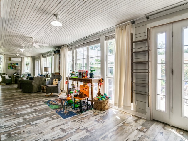 sunroom / solarium with ceiling fan, plenty of natural light, and a wall mounted AC