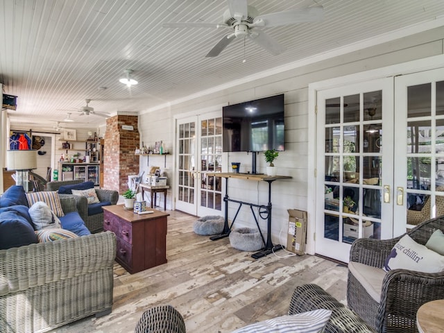 living room featuring ceiling fan, light hardwood / wood-style floors, and french doors