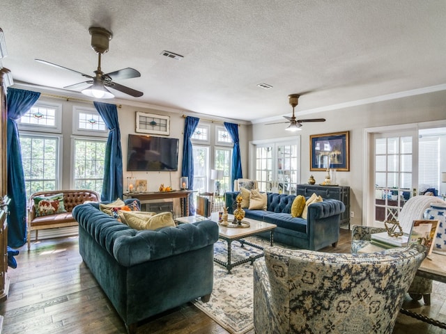 living room with ceiling fan, a textured ceiling, dark hardwood / wood-style floors, and ornamental molding