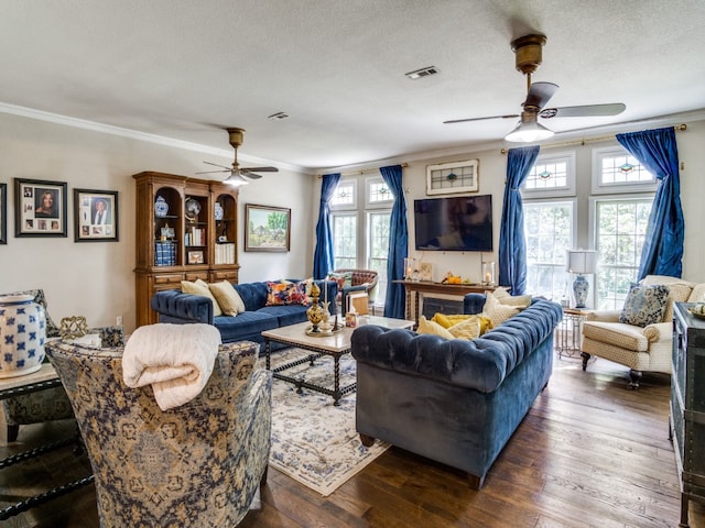 living room with ceiling fan, a textured ceiling, crown molding, and dark hardwood / wood-style flooring