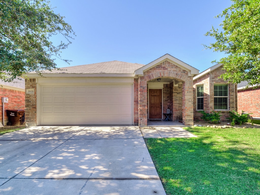 single story home featuring a garage and a front lawn