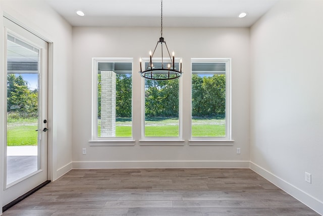 unfurnished dining area featuring light hardwood / wood-style flooring and a chandelier