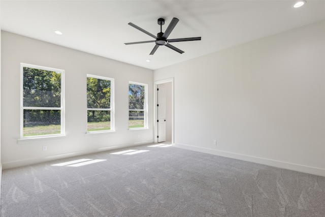 carpeted empty room with a wealth of natural light and ceiling fan