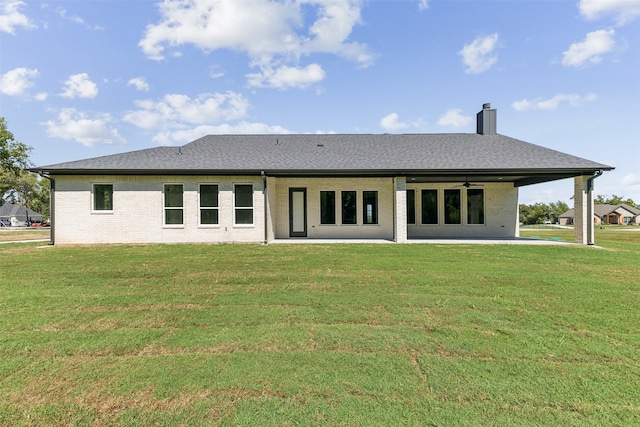 back of property with a yard, ceiling fan, and a patio area