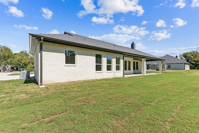 back of house with a patio, central air condition unit, and a yard