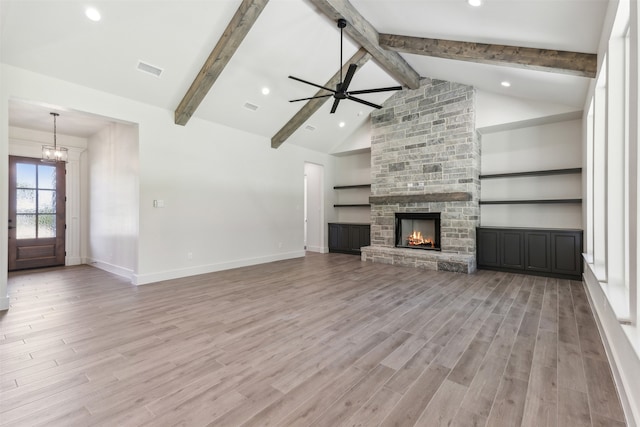 unfurnished living room with light wood-type flooring, a fireplace, and beam ceiling