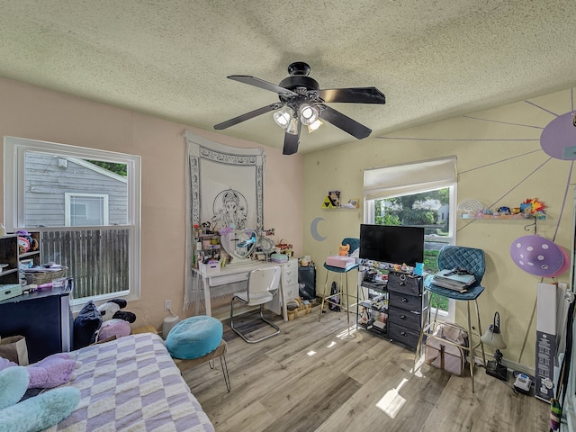 bedroom with light wood-type flooring, a textured ceiling, and ceiling fan