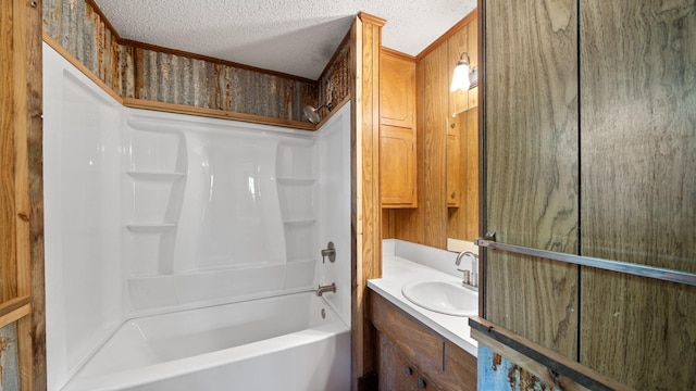 bathroom with vanity,  shower combination, and a textured ceiling