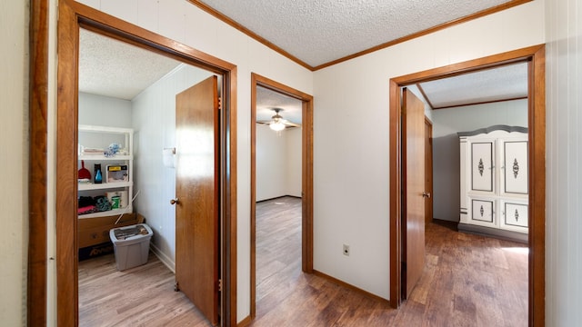 corridor with crown molding, hardwood / wood-style floors, wood walls, and a textured ceiling