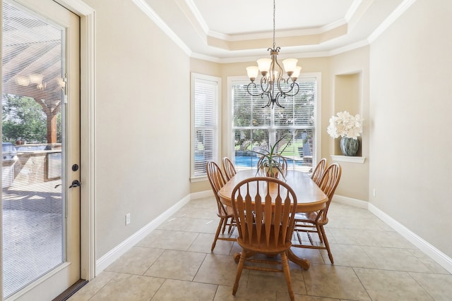 dining space with ornamental molding, a chandelier, a raised ceiling, and light tile patterned flooring