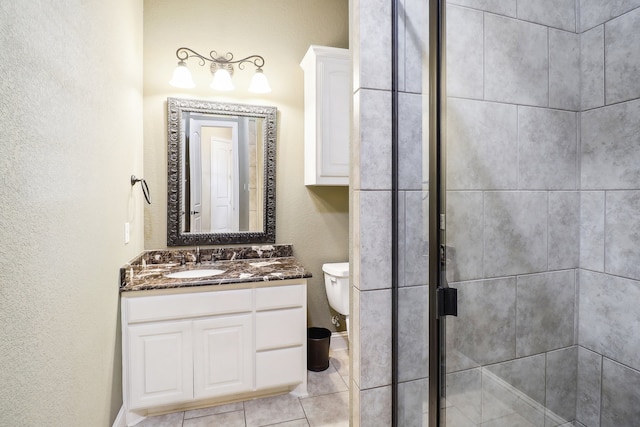 bathroom with vanity, tile patterned flooring, toilet, and an enclosed shower