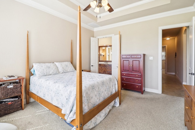 carpeted bedroom with crown molding, ceiling fan, ensuite bathroom, and a raised ceiling