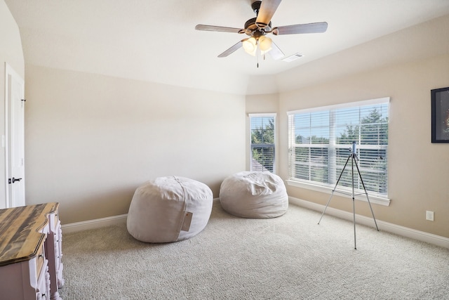 living area featuring carpet and ceiling fan