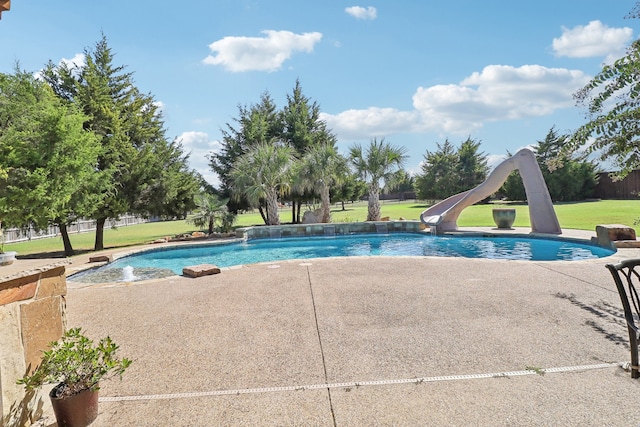 view of swimming pool featuring a lawn, a water slide, and a patio area