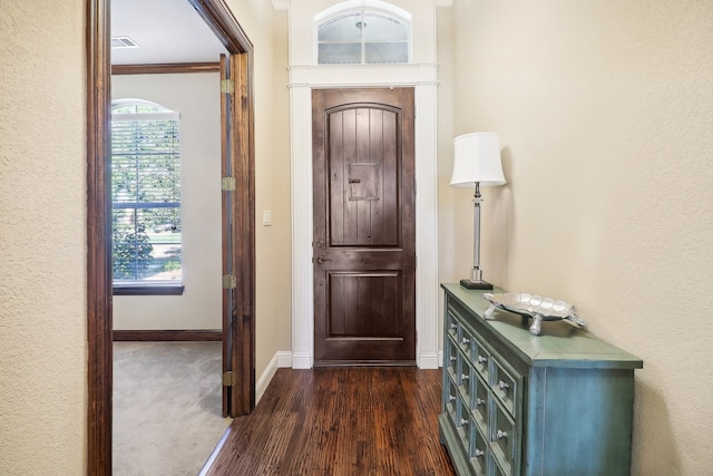 entrance foyer with ornamental molding and dark hardwood / wood-style flooring