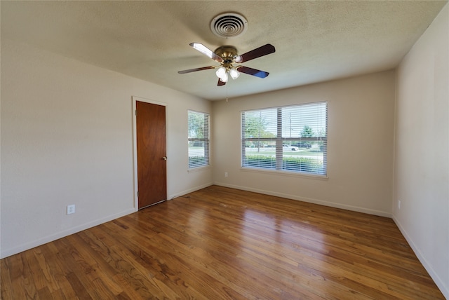 spare room with ceiling fan, hardwood / wood-style flooring, and a textured ceiling