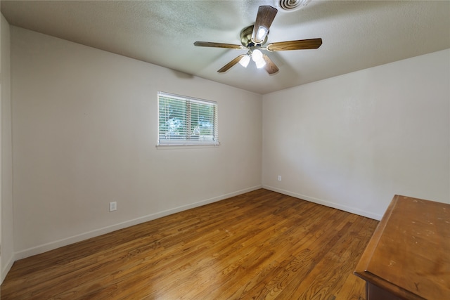 spare room with a textured ceiling, hardwood / wood-style floors, and ceiling fan