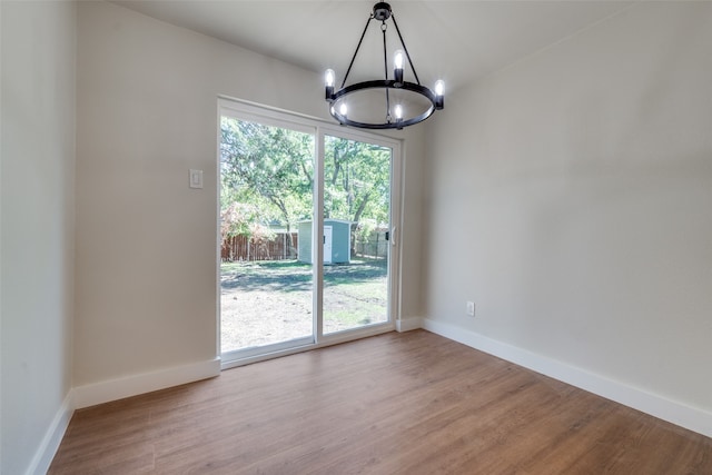 unfurnished dining area with a notable chandelier and light hardwood / wood-style flooring