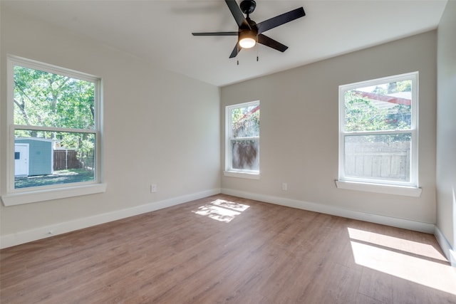 spare room with ceiling fan, a healthy amount of sunlight, and light wood-type flooring