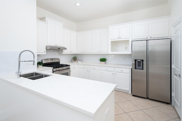 kitchen with sink, white cabinetry, appliances with stainless steel finishes, light tile patterned flooring, and kitchen peninsula