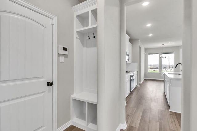 mudroom with a chandelier, light hardwood / wood-style flooring, and sink