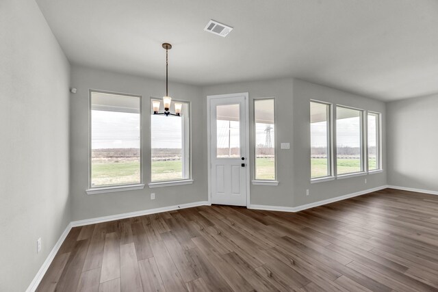 interior space with plenty of natural light, dark hardwood / wood-style floors, and a notable chandelier