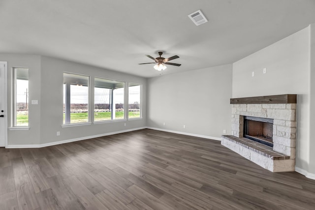 unfurnished living room featuring a fireplace, dark hardwood / wood-style flooring, and ceiling fan