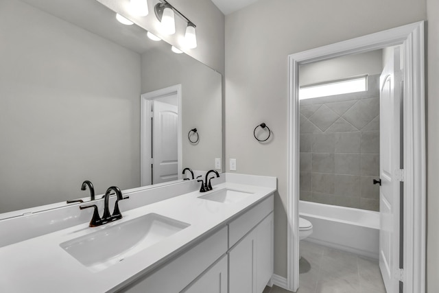 full bathroom featuring vanity, tiled shower / bath combo, and toilet