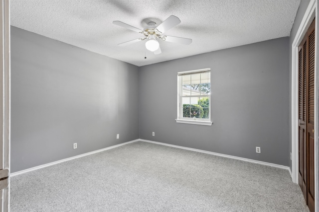 unfurnished bedroom featuring a closet, carpet, a textured ceiling, and ceiling fan