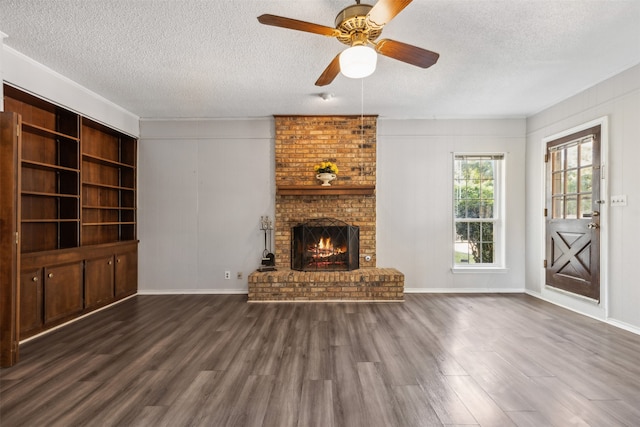 unfurnished living room with a brick fireplace, ceiling fan, hardwood / wood-style floors, and a textured ceiling