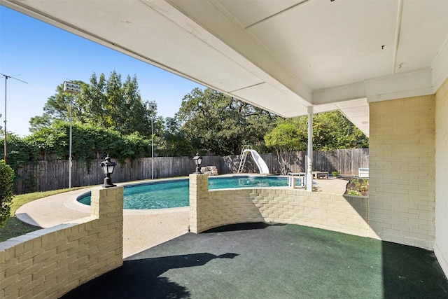 view of pool featuring a water slide, a fenced backyard, a fenced in pool, and a patio area
